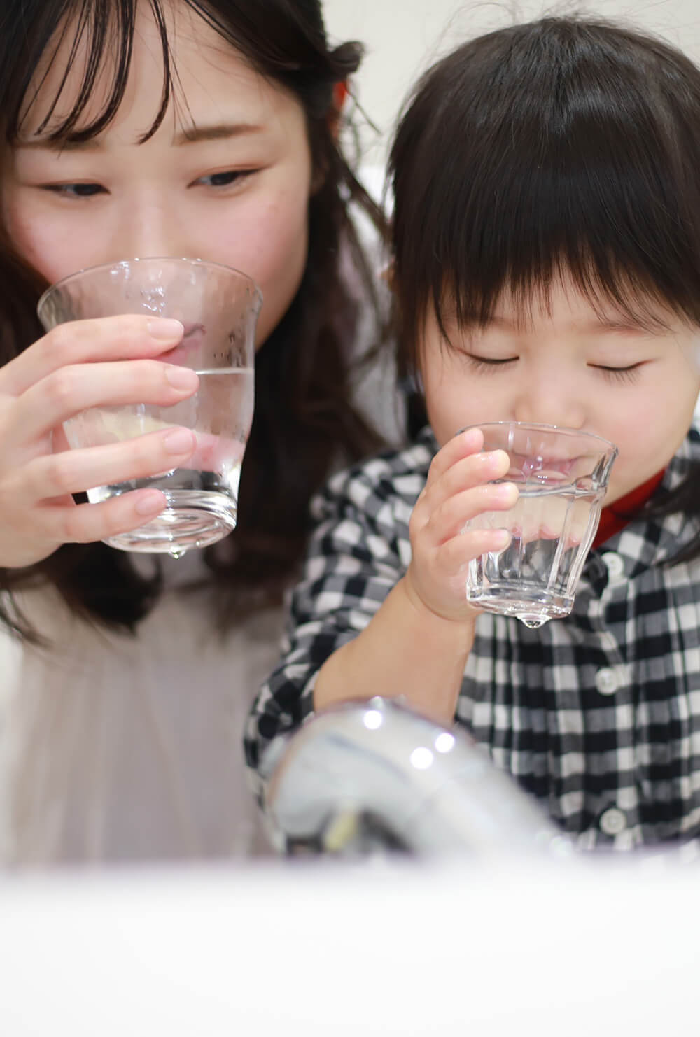Mother and child drinking water together