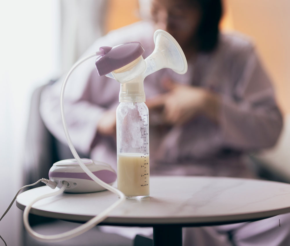 Breast pump with expressed milk bottle on table