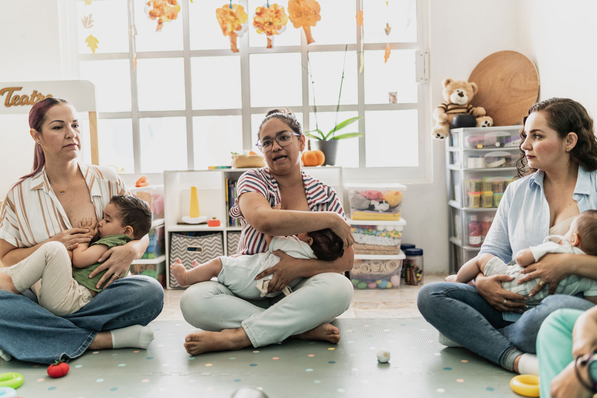 Mothers breastfeeding babies in supportive group setting
