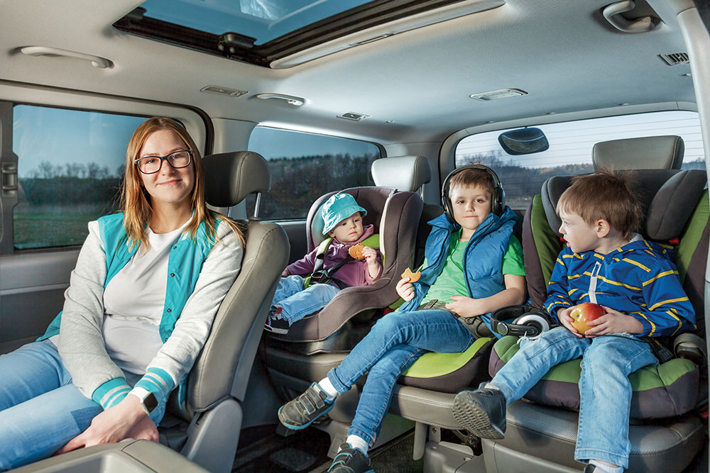 Woman with children in car enjoying snacks