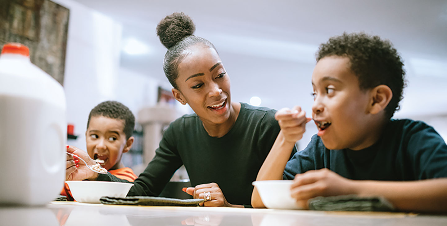 Parent and two children enjoying a meal together.